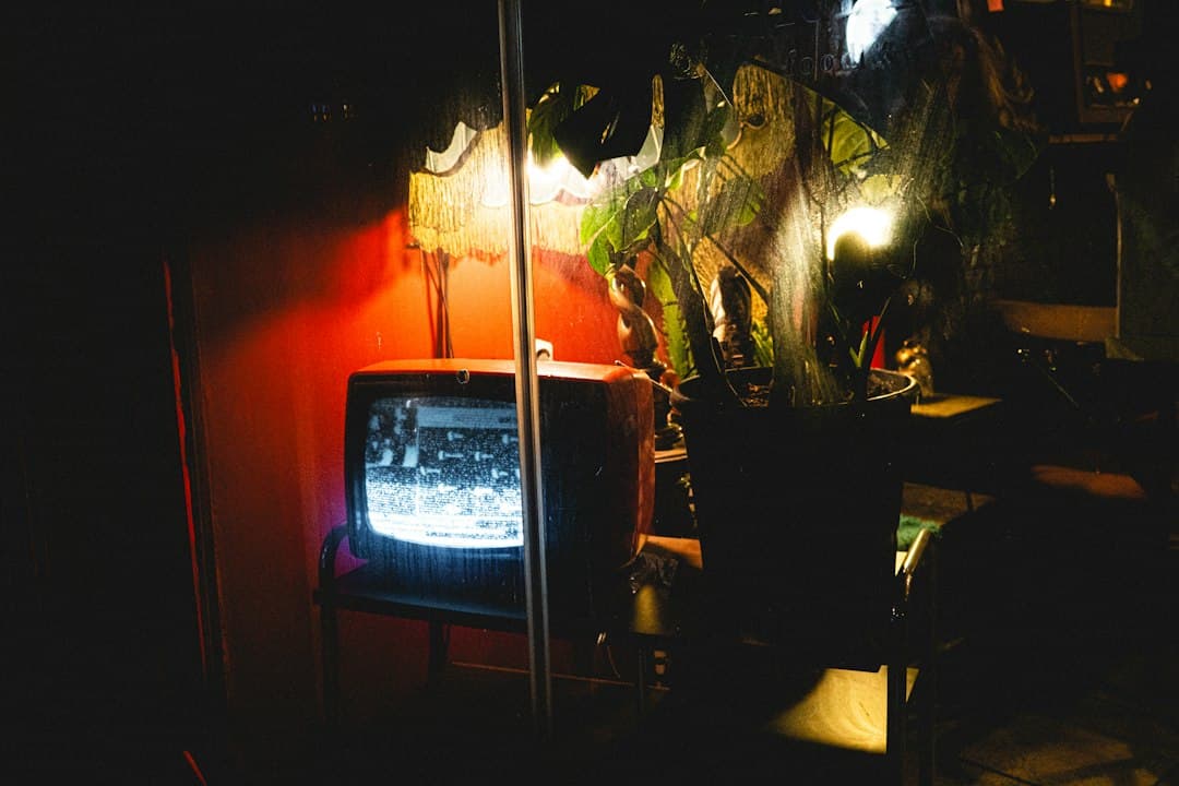 A small TV glowing in a dim room with plants and a warm lamp – an evening of live TV in the TiviMate app